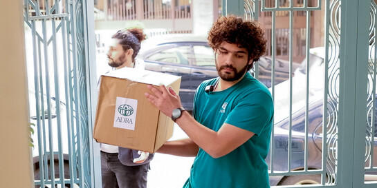 Ein Mitarbeiter der Hilfsorganisation ADRA verteilt ein Hilfspaket im Libanon