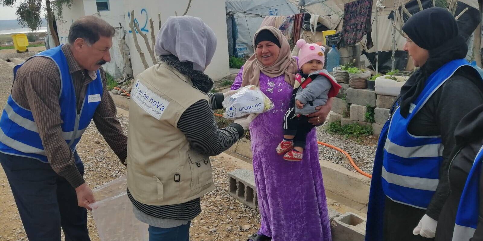 Helfer und Helferinnen von arche noVa verteilen in einem Flüchtlingscamp im Irak Hilfsgüter