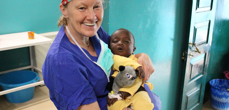 Ärztin hält in der Kinderambulanz Baby auf dem Arm Ärztin hält in der Kinderambulanz Baby auf dem Arm