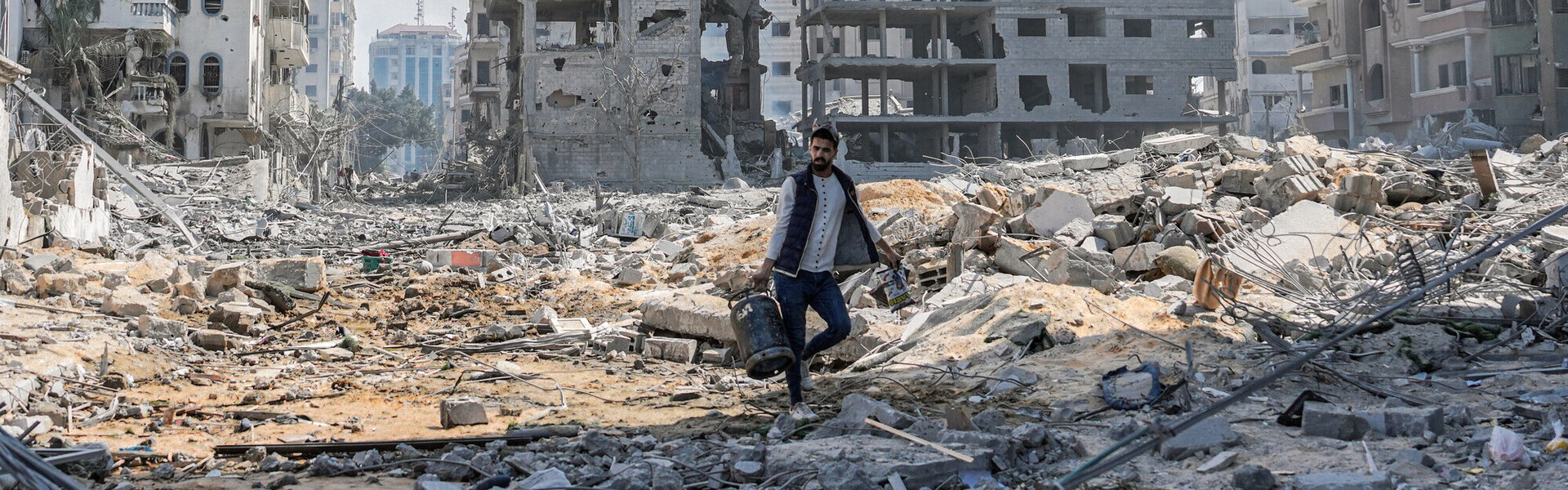 Ein Mann in Gaza umgeben von zerbombten Häusern