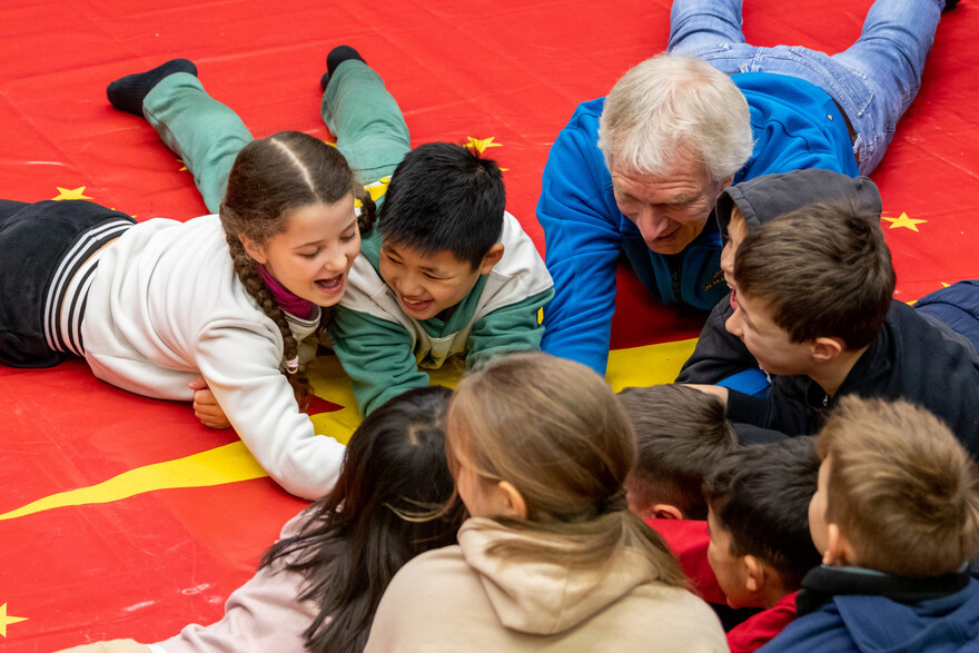 Ein Helfer spielt mit geflüchteten Kindern Ein Helfer spielt mit geflüchteten Kindern