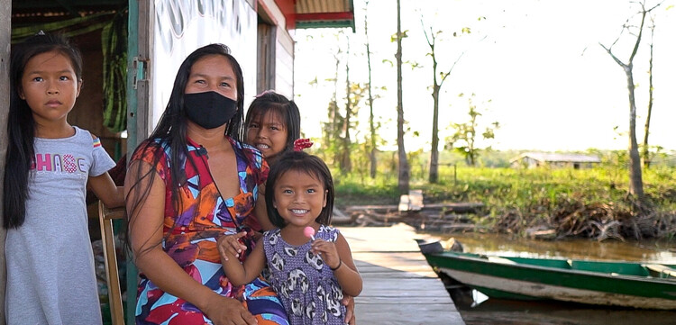 Célia mit ihren drei Kindern auf der Veranda ihres Hauses im Amazonas Célia mit ihren drei Kindern auf der Veranda ihres Hauses im Amazonas