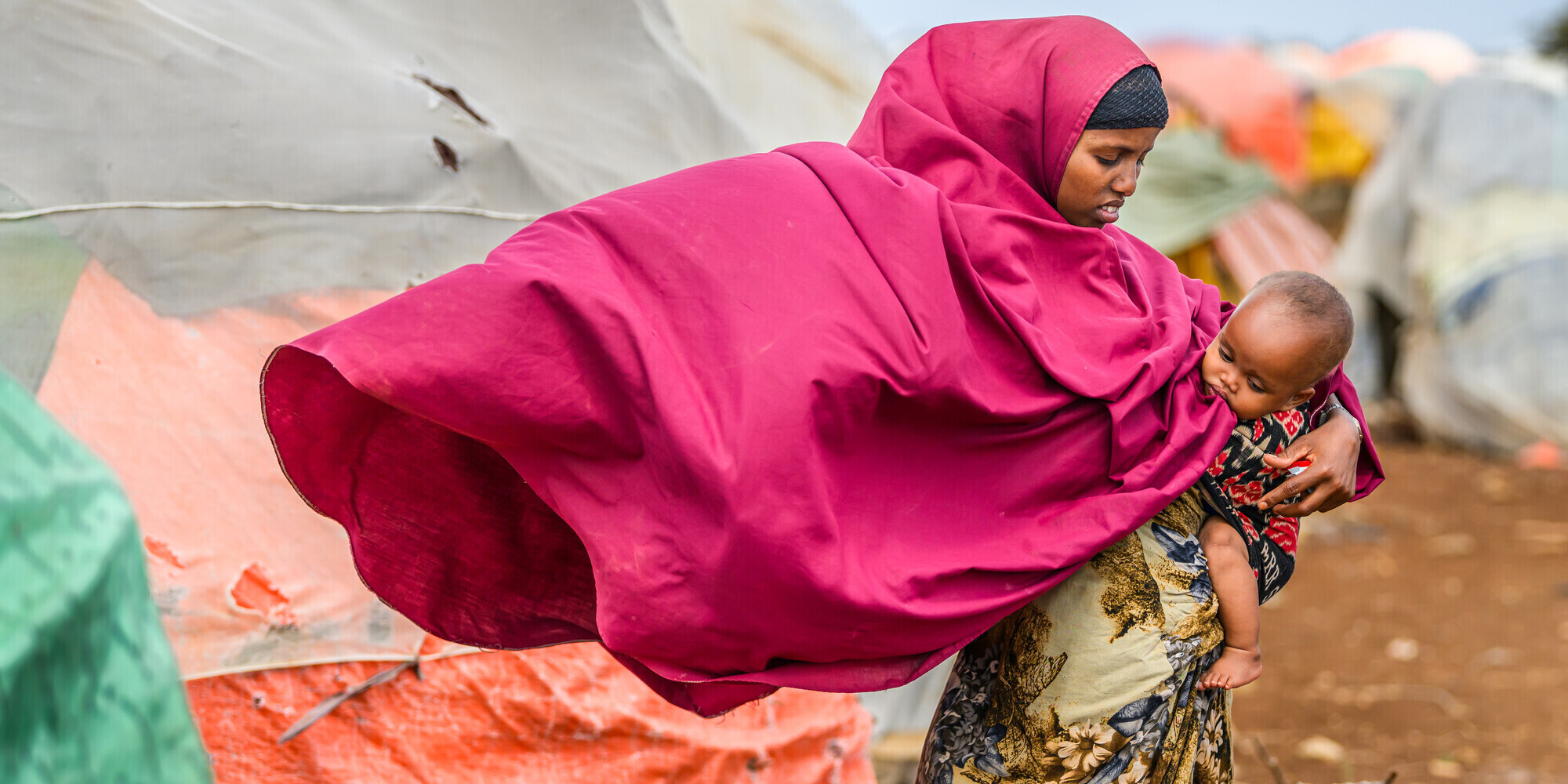  Eine Frau hält in einem Geflüchtetencamp in Somalia ein Kind auf dem Arm