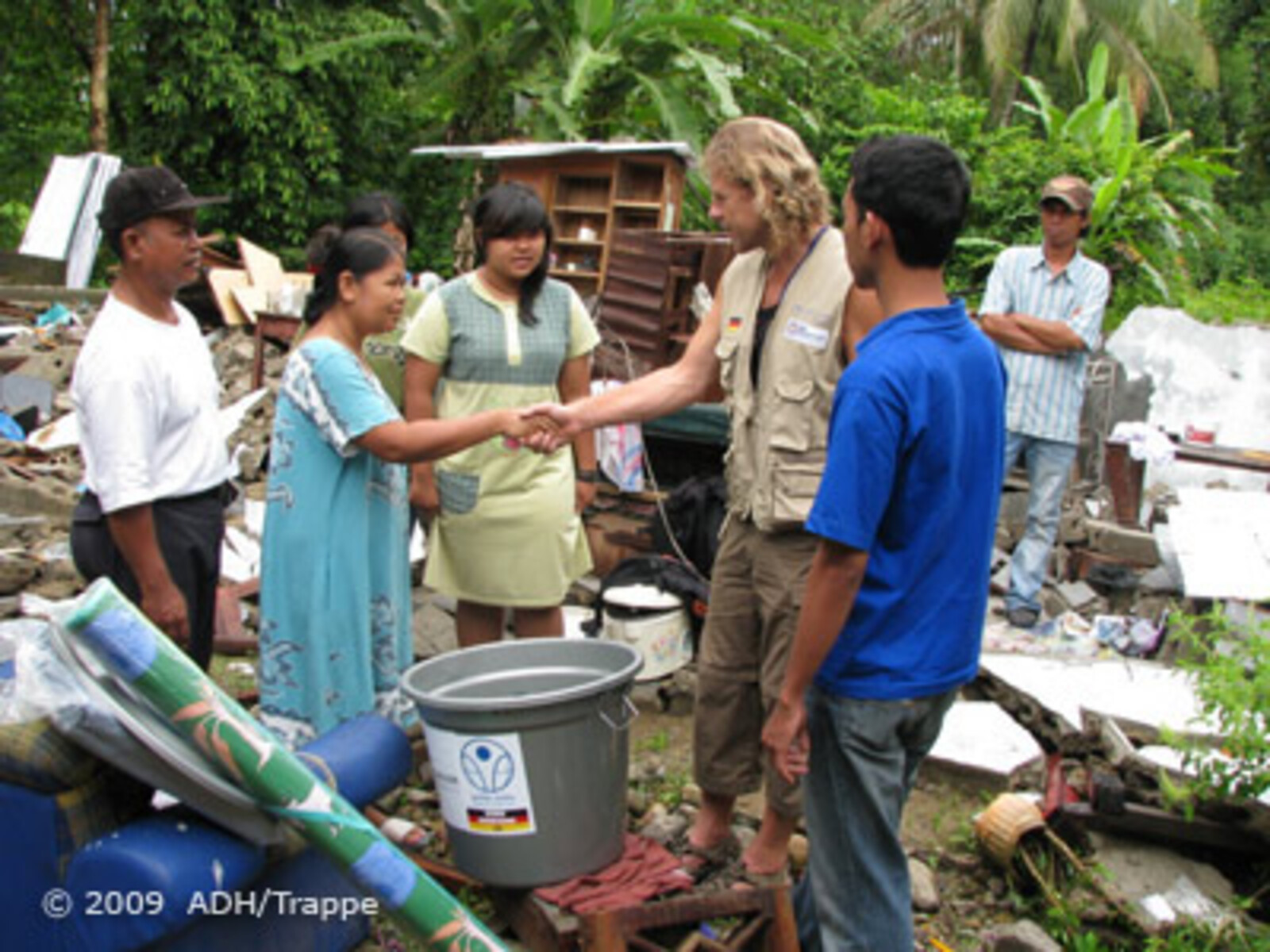 Katastrophen Südostasien: Helfer redet mit Betroffenen und schüttelt ihre Hände