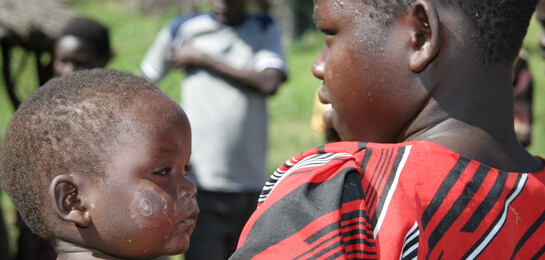 In Uganda ist die Situation für Kinder häufig schwierig, da sie unter Kämpfen in Nachbarregionen zu leiden haben. Ein Junge trägt seinen kleinen Bruder.