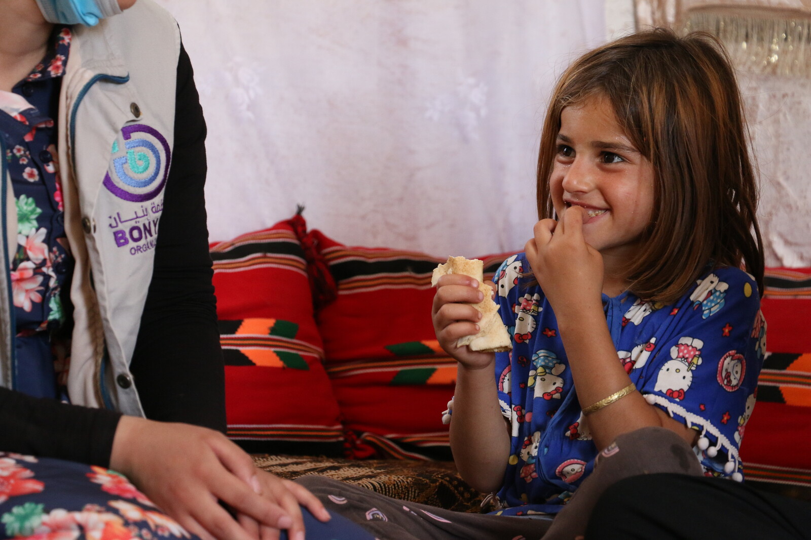 Mädchen im Erdbebengebiet Türkei/Syrien mit Mitarbeiterin einer Hilfsorganisation