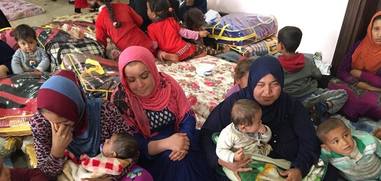 In einem Flüchtlingslager in Makhmour sitzen viele Frauen und Kinder. Sie sind Flüchtlinge und Betroffene des Krieges in Syrien.
