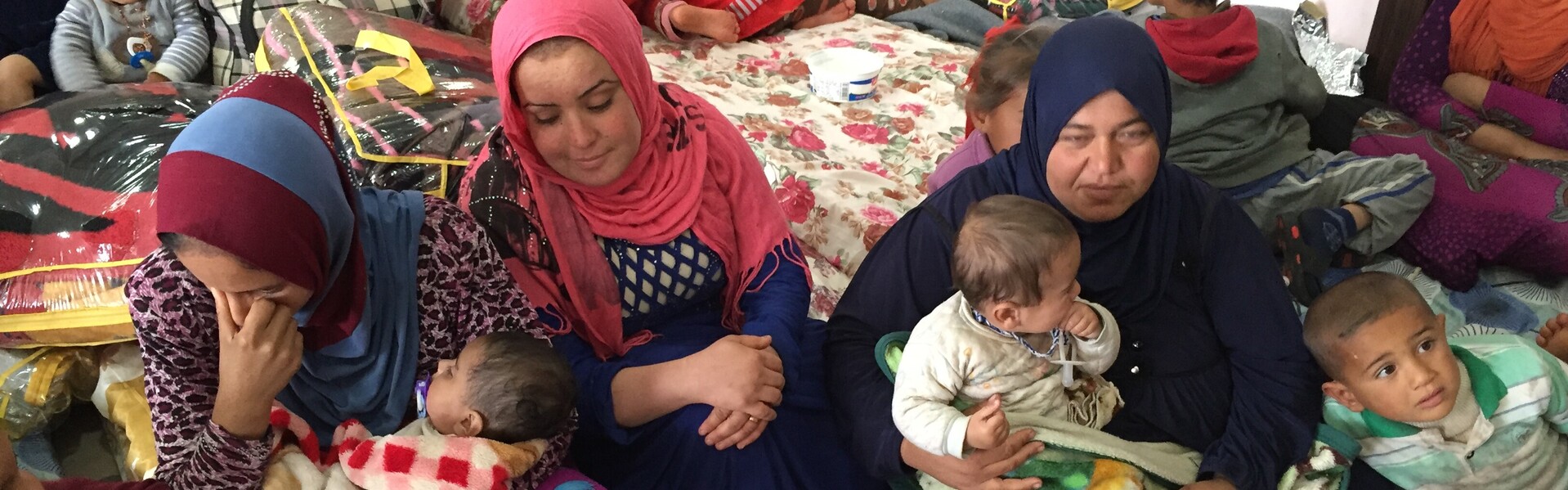 In einem Flüchtlingslager in Makhmour sitzen viele Frauen und Kinder. Sie sind Flüchtlinge und Betroffene des Krieges in Syrien.