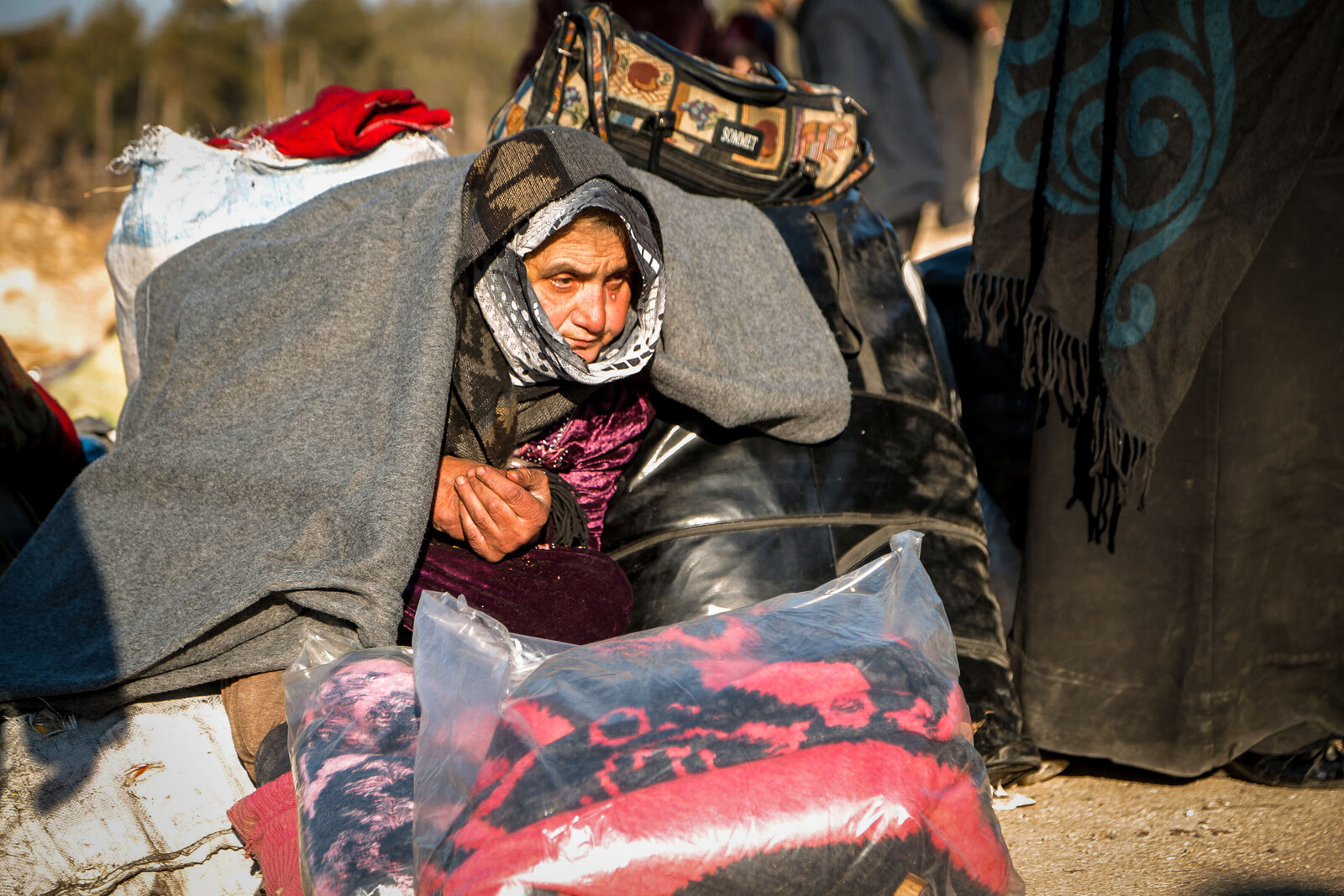 Eine Frau deckt sich in Aleppo mit Decken ein