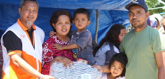 Helfer & eine Familie in einem Kinderschutzzentrum in Indonesien