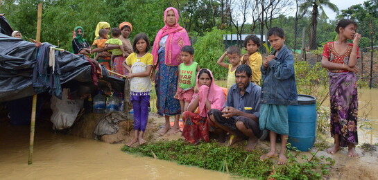 Rohingya Flüchtlinge stehen vor einem überfluteten Zelt in Bangladesch