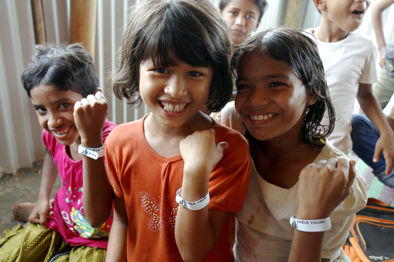 Kinder in Bangladesch zeigen ihr Armband.