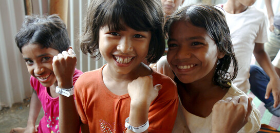 Kinder in Bangladesch zeigen ihr Armband.