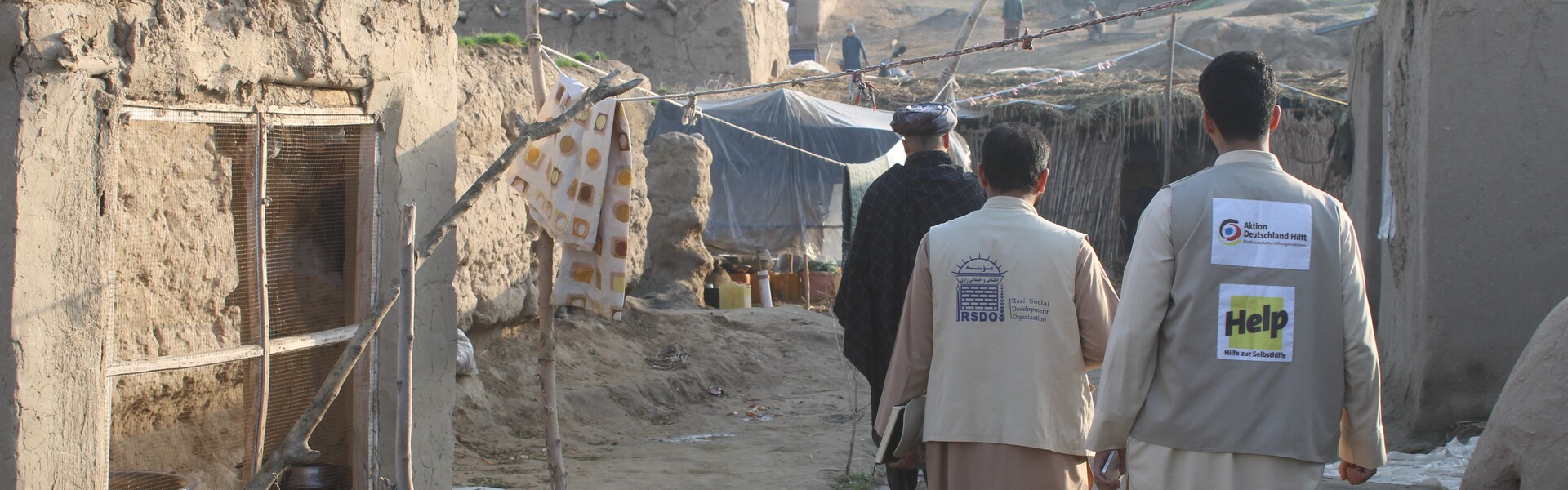 Zwei Mitarbeiter von Help gehen durch eine Wohngegend in Afghanistan Zwei Mitarbeiter von Help gehen durch eine Wohngegend in Afghanistan