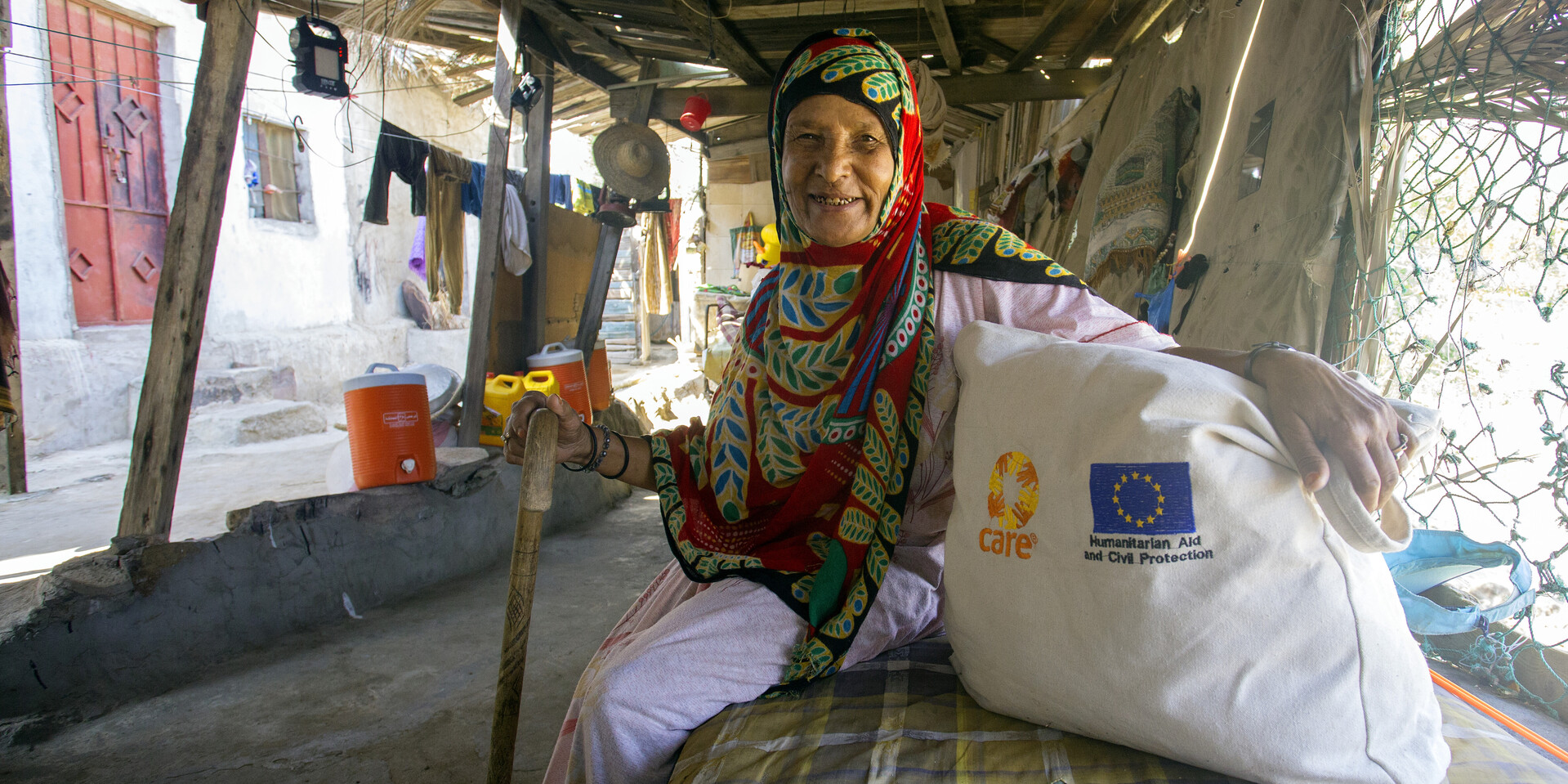 2)	Eine Frau sitzt in einer notdürftigen Hütte im Jemen, ihr Zuhause hat sie verloren.