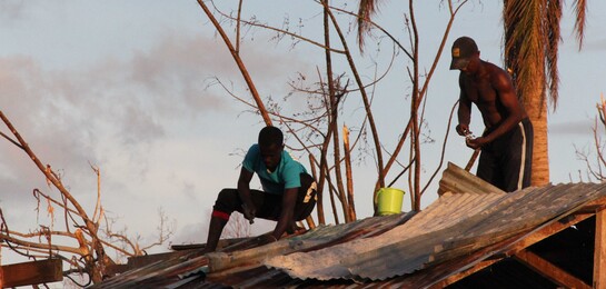 Helfer reparieren ein zerstörtes Haus auf Haiti.