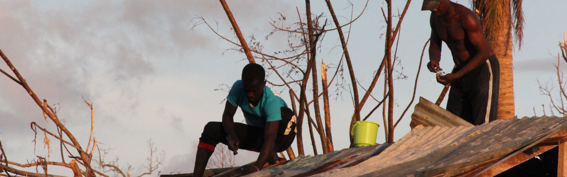 Helfer reparieren ein zerstörtes Haus auf Haiti.
