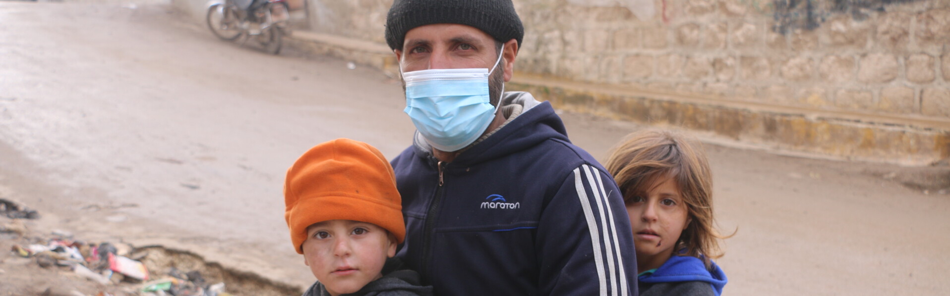 Ein Vater in Syrien transportiert auf einem Motorrad Lebensmittel mit seinen zwei Kindern 
