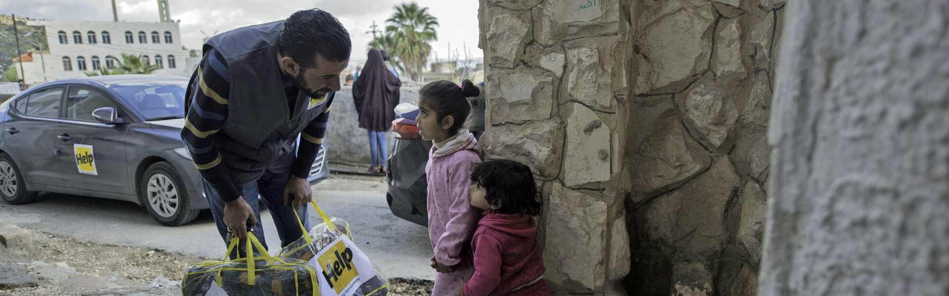 Mitarbeiter von Help - Hilfe zur Selbsthilfe verteilt Hilfsgüter an Kinder in Syrien