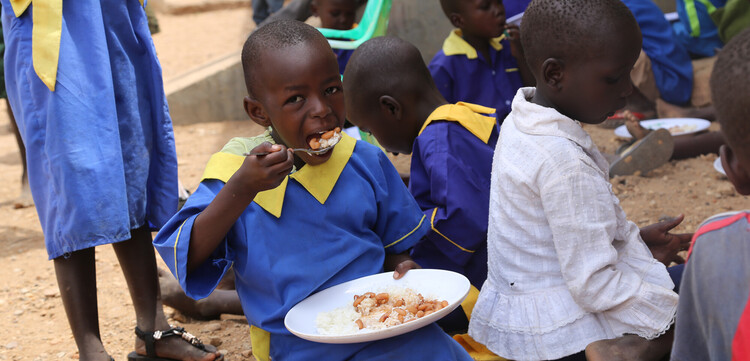 Ein Schulkind im Südsudan in Afrika beim Essen Ein Schulkind im Südsudan in Afrika beim Essen