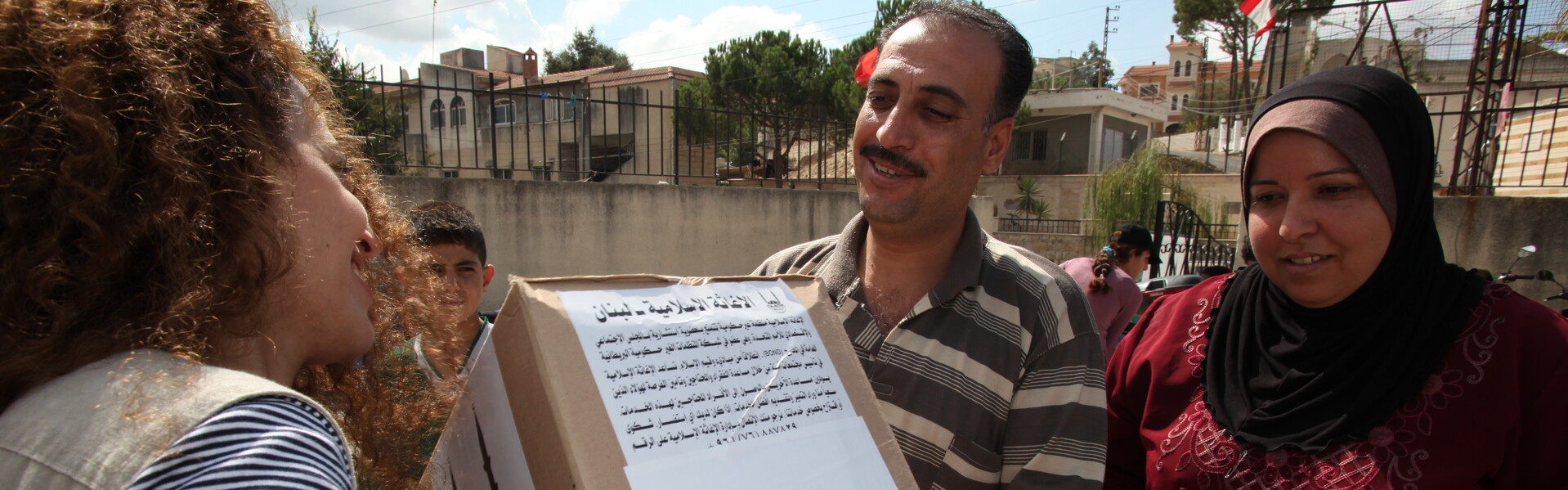 Eine Frau übergibt ein Paket an eine Familie im Libanon