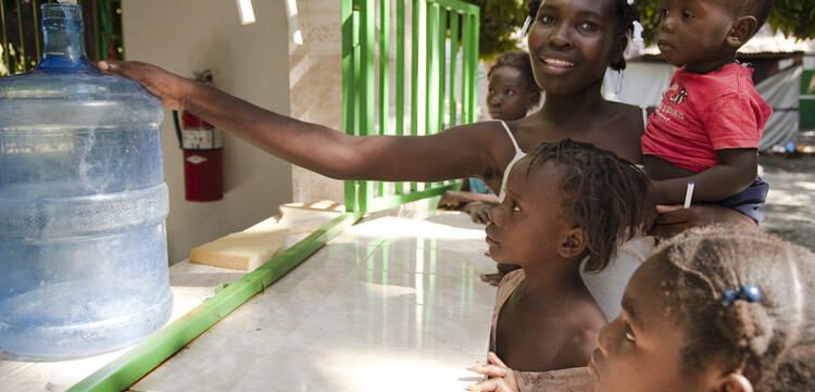 Nach dem Erdbeben in Haiti erhält eine Frau mit ihren Kindern Trinkwasser. Nach dem Erdbeben in Haiti erhält eine Frau mit ihren Kindern Trinkwasser.