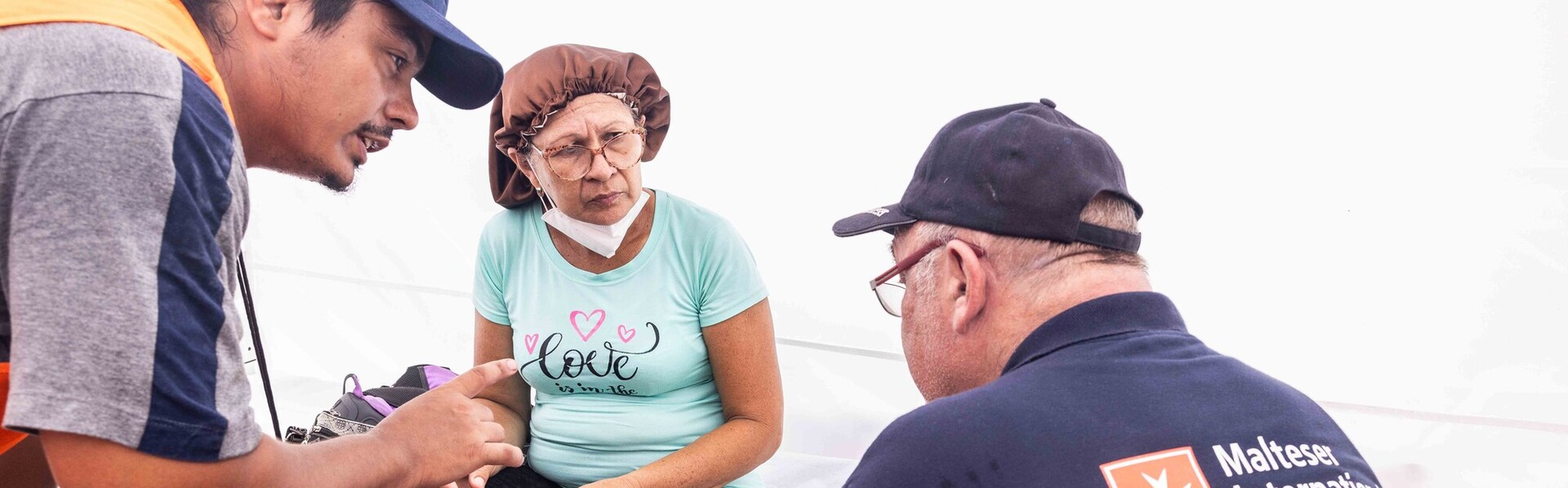 Eine Frau spricht mit einem Helfer der Malteser Eine Frau spricht mit einem Helfer der Malteser