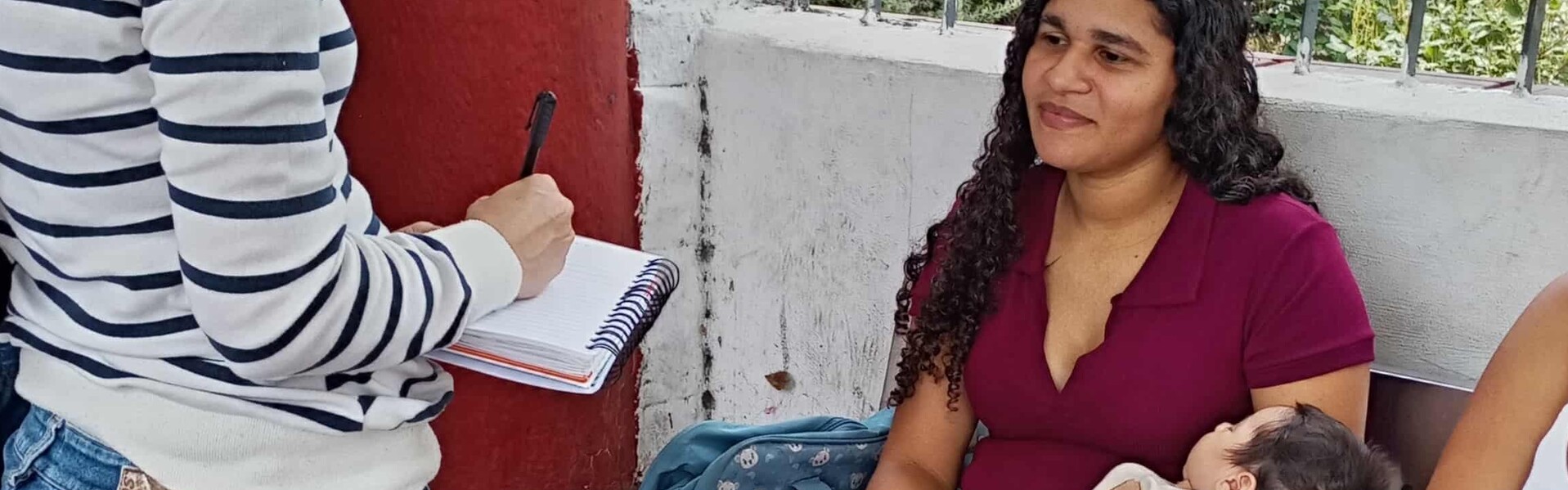 Eine Frau schreibt sich Daten einer jungen Mutter und ihrem Baby auf, nach den Erdbeben in Venezuela