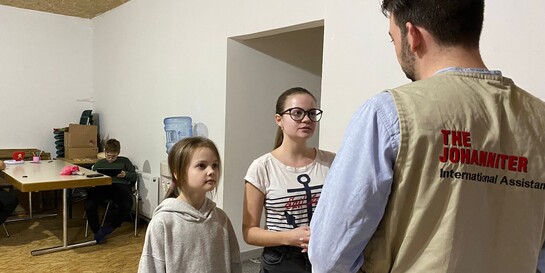 Ein Helfer der Johanniter mit Geflüchteten aus der Ukraine