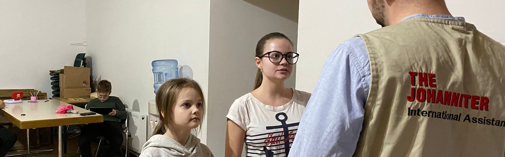 Ein Helfer der Johanniter mit Geflüchteten aus der Ukraine