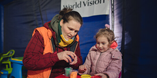 Eine Helferin von World Vision mit Kind aus der Ukraine in Rumänien