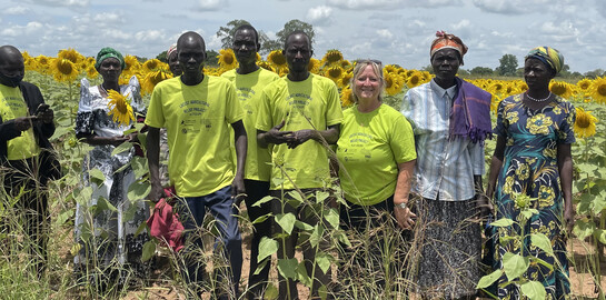 Projektleiterin Colleen Stevenson (2. v. r.) besuchte die drei begünstigten Dörfer im Norden Ugandas.  Die Landwirtschaftshilfe zahlt sich aus: Die Felder bringen Ernten und neues Saatgut für weitere Familien