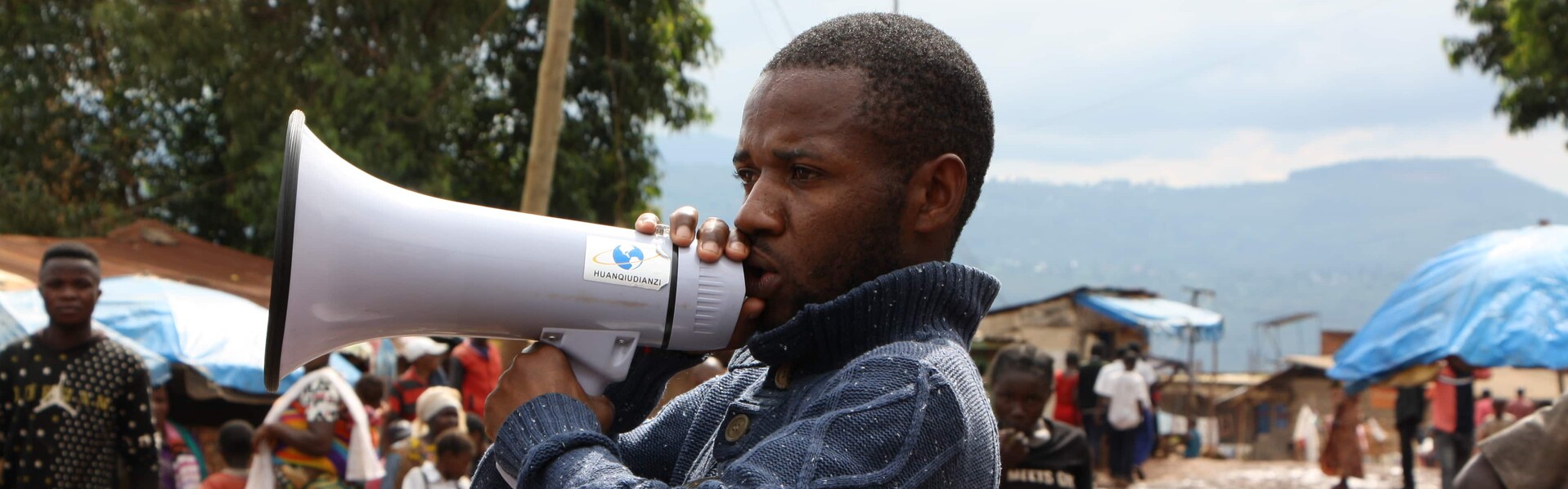 Ein Helfer informiert über Ebola-Schutzmaßnahmen in der Demokratischen Republik Kongo Ein Mann in der DR Kongo spricht in ein Megaphon
