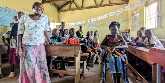 Anai aus dem Flüchtlingslager Rhino Camp in Uganda, die dank eines Rollstuhls von Handicap International die Schule besuchen kann