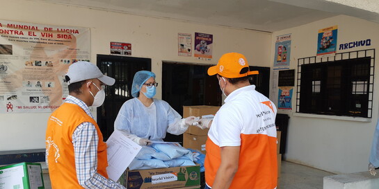 Drei Helfer:innen von World Vision verteilen Medikamente und andere Hilfsgüter (Symbolbild)