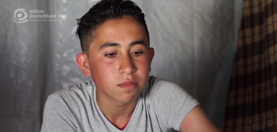 Das Kind Mustapha sitzt im Flüchtlingslager und spricht davon, dass er sich kein menschenwürdiges Leben leisten.