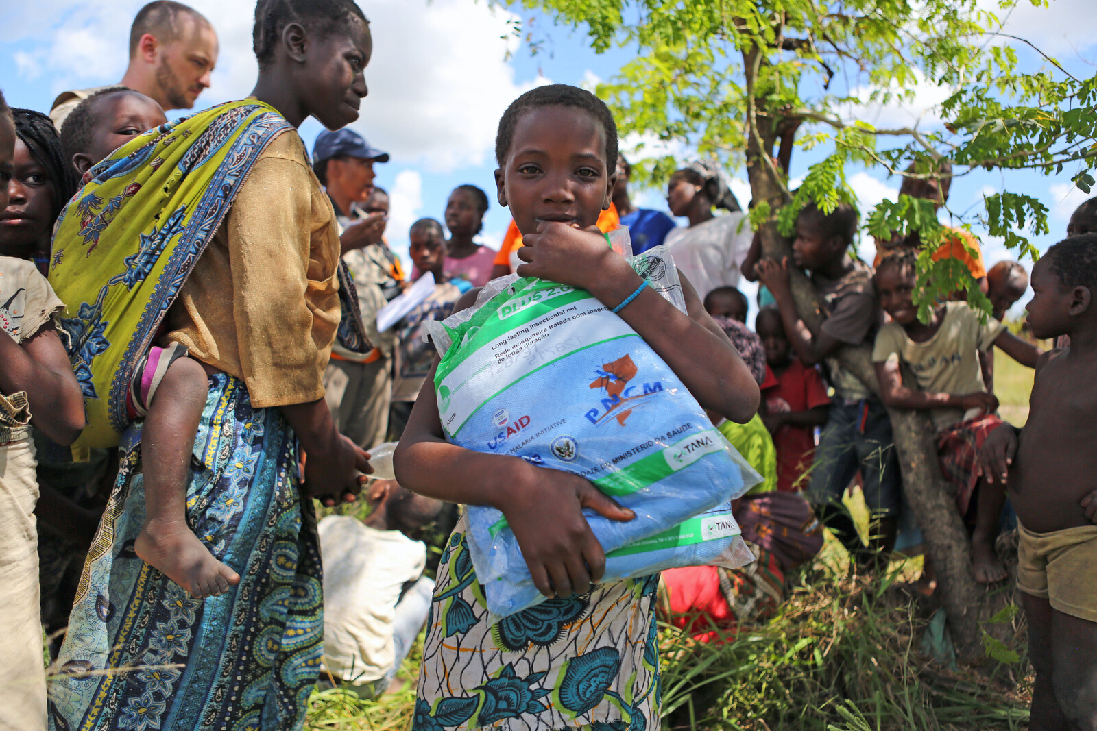 Ein Mädchen in Mosambik hält Hilfslieferungen im Arm