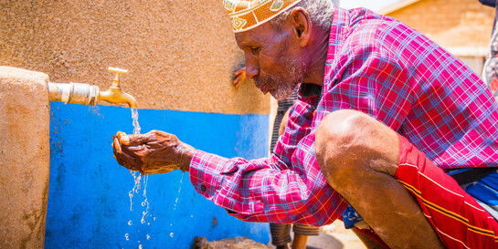 Wasser läuft in die Hand eines Mannes in Äthiopien 