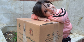 Kind freut sich über Hilfspaket nach dem Erdbeben in der Türkei & Syrien