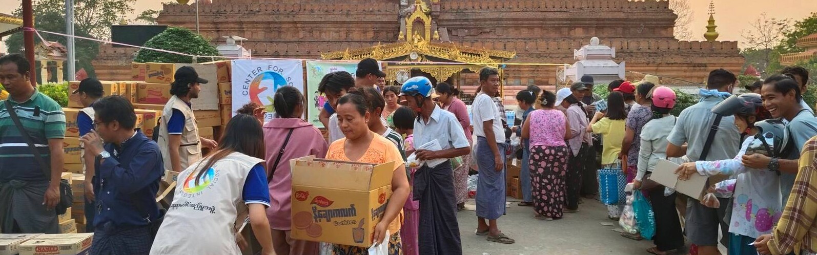 Helfer:innen und Betroffene des Erdbebens in Myanmar bei der Verteilung von Hilfsgütern