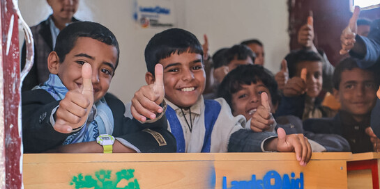 Kinder in einer Schule im Jemen halten den Daumen in die Kamera