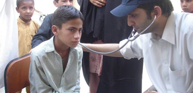 untersuchung-junge Flut Pakistan: Arzt untersucht einen Jungen