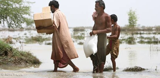 Flut Pakistan: Männer mit Hilfsgütern