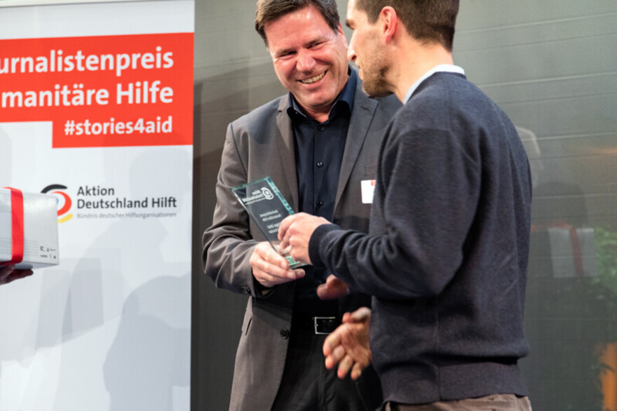 Gewinner Sebastian Schneider nimmt den Journalistenpreis Humanitäre Hilfe entgegen Gewinner Sebastian Schneider nimmt den Journalistenpreis Humanitäre Hilfe entgegen