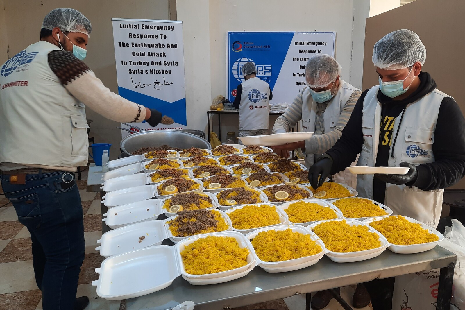 Helfer:innen bereiten Essen für hilfsbedürftige Menschen vor