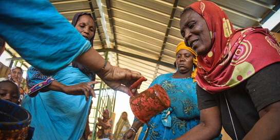 Helfer vom ASB versorgen geflüchtete Frauen aus Mali mit einer warmen Mahlzeit