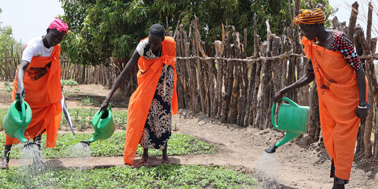 Zwei Frauen im Südsudan bewässern den Gemeinschaftsgarten der Matiei Primary Health Care Unit von World Vision 