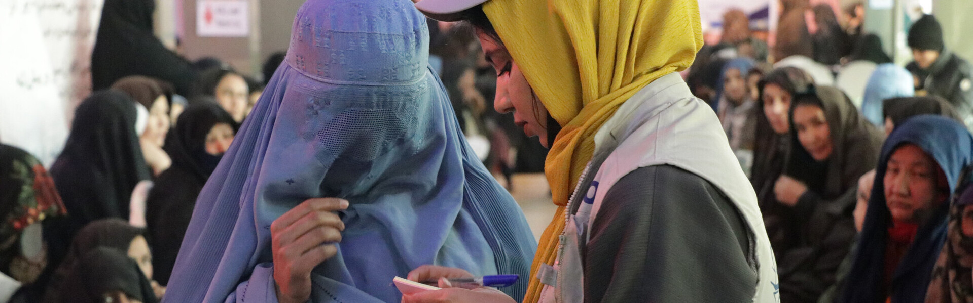 Eine Helferin spricht mit einer Frau, die eine blaue Burka trägt, Copyright Help – Hilfe zur Selbsthilfe