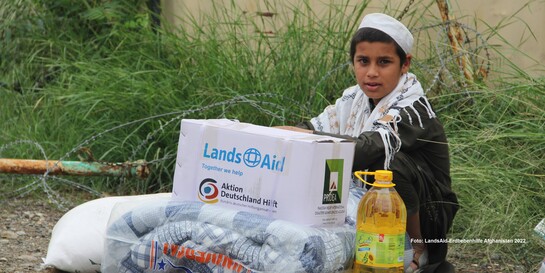 Ein Junge in Afghanistan mit Hilfsgütern 