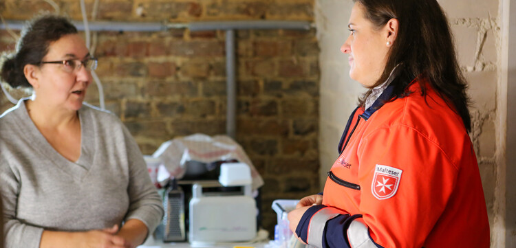 Malteser-Helferin im Gespräch mit einer vom Hochwasser betroffenen Frau 